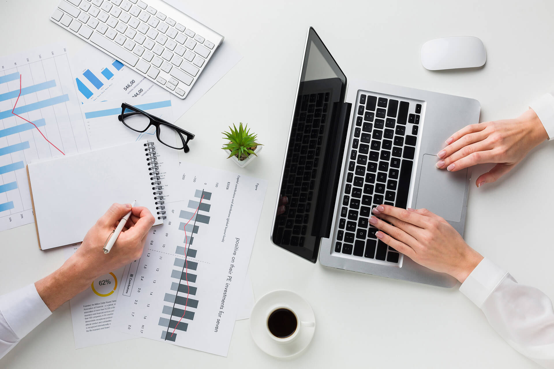 Woman hands writing on report near laptop on white office desk top view