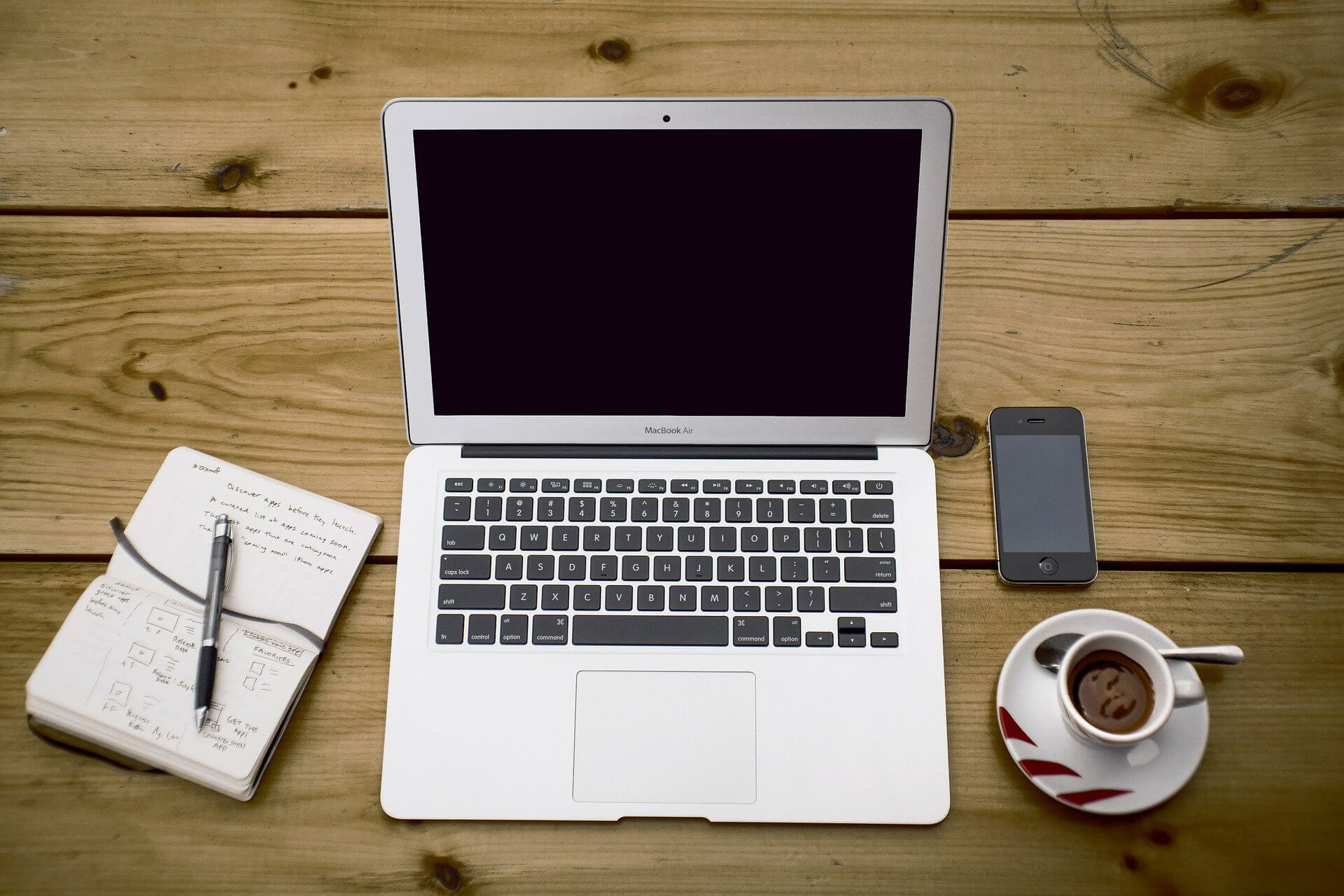 Laptop coffee notbook and cellphone on the wooden desk